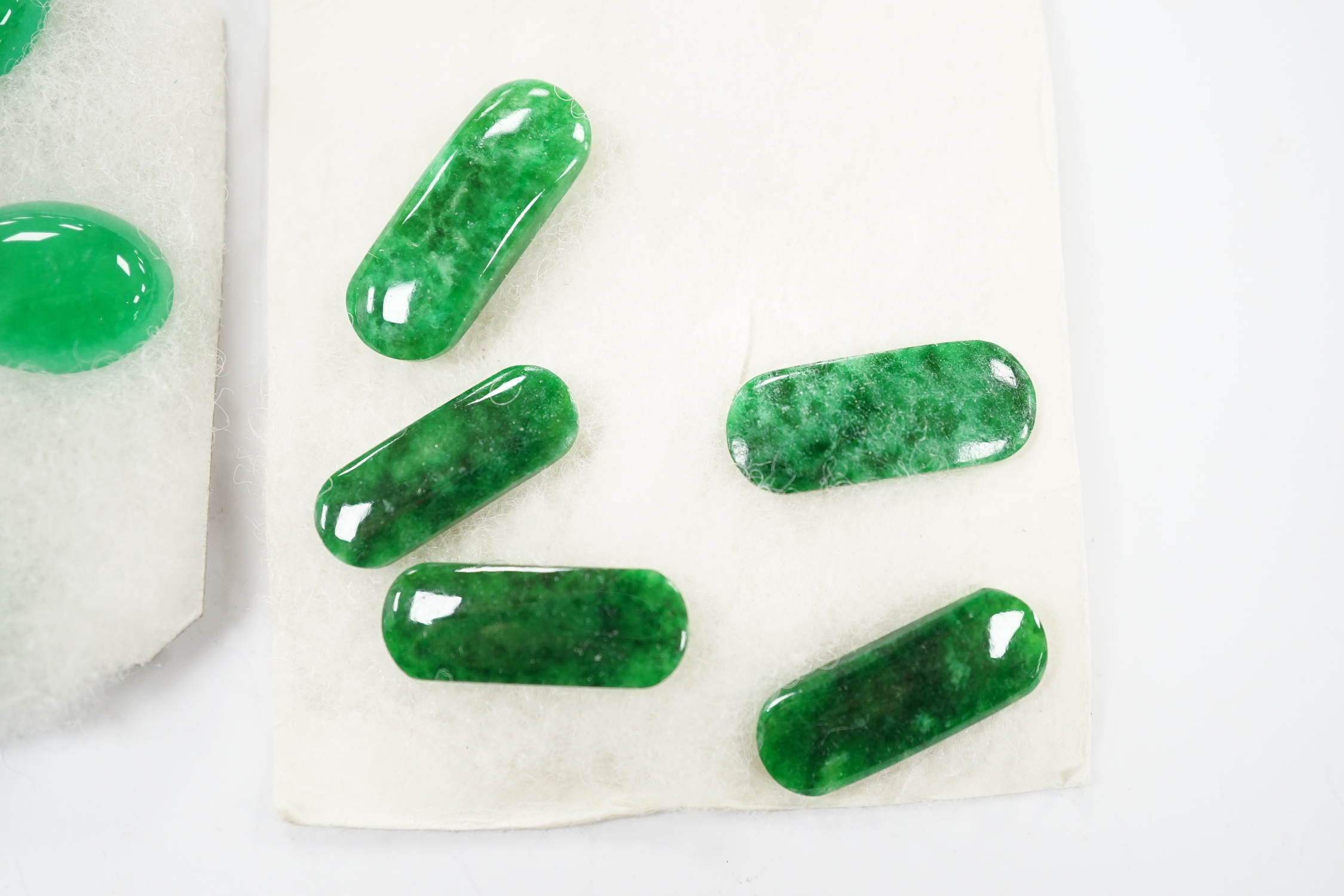 Five unmounted jadeite cabochons, approx. 15mm and five unmounted ovoid jadeite cabochons, approx. 22mm, (fixed to a card background).